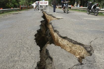 In this photo taken on Tuesday, Feb. 7, 2012, motorists drive past a huge crack on a road, which was damaged by a magnitude-6.9 earthquake at Guihulngan township, Negros Oriental province in central Philippines that shook at least three central Philippine provinces Monday. Dozens of people were still missing Tuesday following the strong earthquake that triggered landslides and damaged buildings and roads on a central Philippine island. (AP Photo)