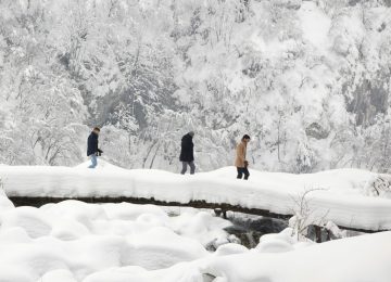 Visitors walk over a snow covered bridge in the national park of Plitvice, Croatia, Friday, March 2, 2018. Most of Croatia was heavily hit by the recent unusually cold weather that gripped Europe. (AP Photo/Darko Bandic)