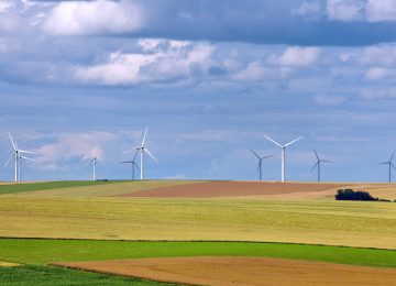 Rural landscape with wind turbines of wind farm amongst fields