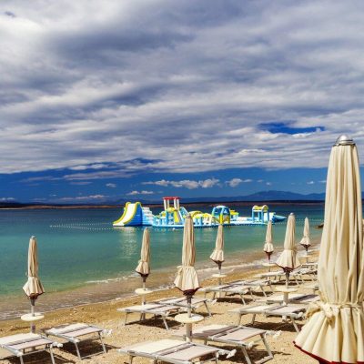 Empty sea beach with closed sun-umbrellas, Croatia, stormy weather, summer