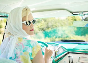 woman-driving-vintage-car-on-road-during-daytime-33678